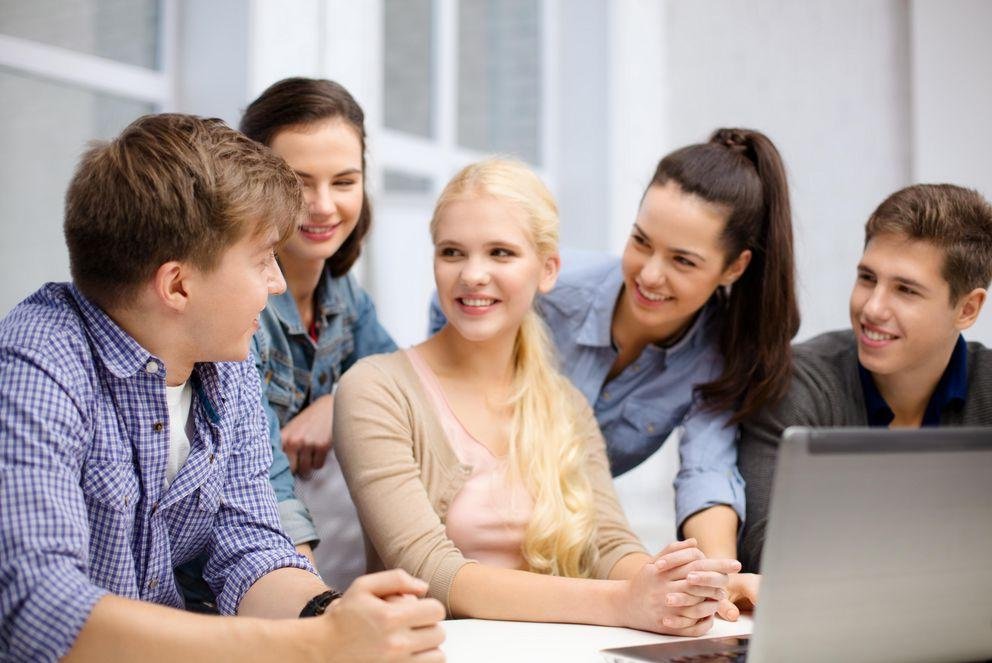 group of smiling students with laptop at school Studierende