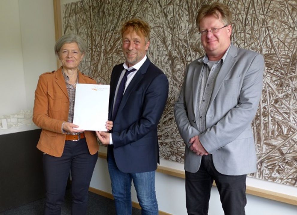 Präsidentin Prof. Dr. Carola Jungwirth überreicht Prof. Dr. Malte Steinbrink die Ernennungsurkunde im Beisein von Dekan Prof. Dr. Karsten Fitz.