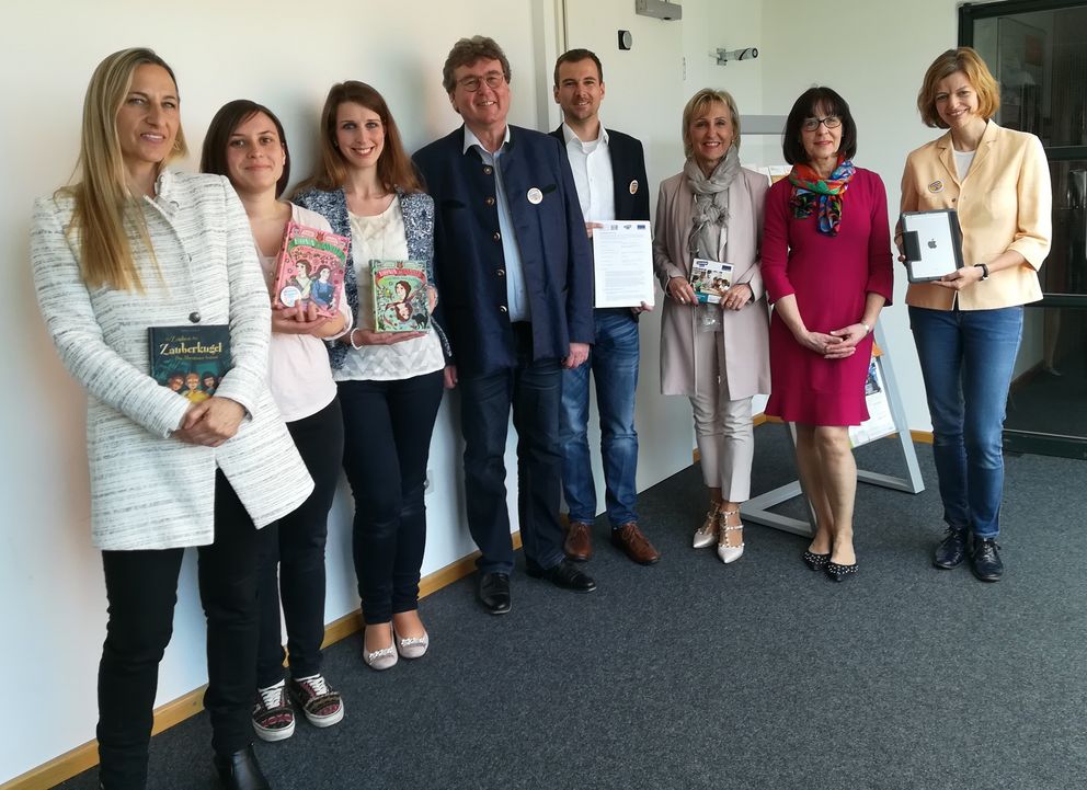 Die Kooperationsverträge und erste an die Schulen ausgelieferte Arbeitsmaterialien präsentieren die Lehrerinnen Bettina Stummer (von links), Isabell Sanftleben, Cosima Tröster-Mehrle (alle Grundschule Haidenhof), Susanne Bulicek, Michaela Kronawitter und Corinna Meurer (alle Grundschule Grubweg) zusammen mit Prof. Dr. Norbert Seibert (Mitte links) und Martin Eder.